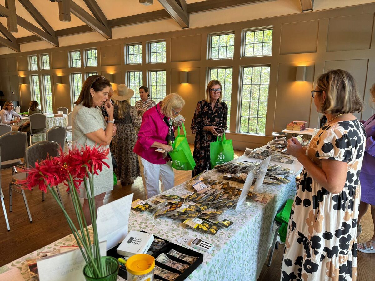Attendees pick out heirloom bulbs, with red spider lilies on the table