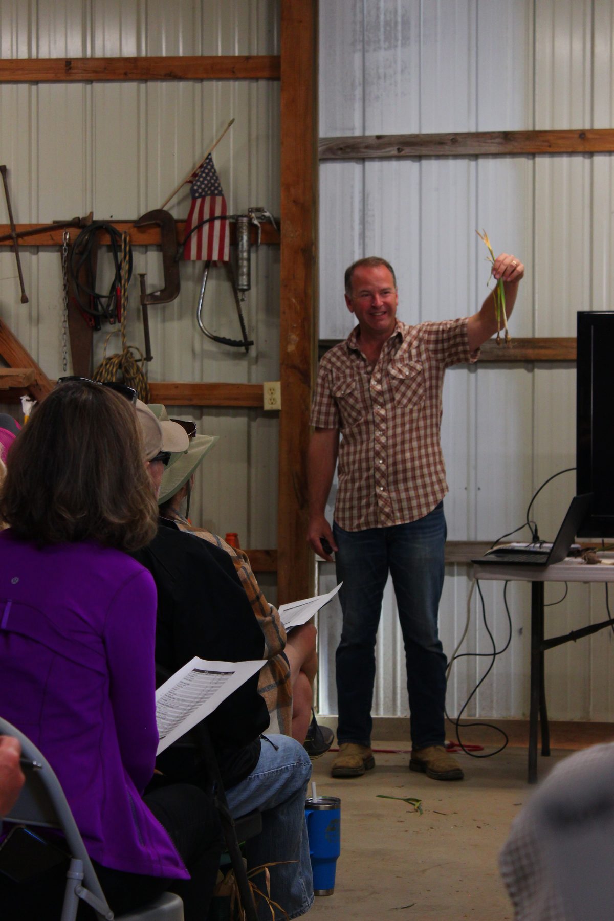 Chris Wiesinger holding up freshly dug bulbs during a talk